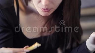 年轻女孩在咖啡馆里吃<strong>快餐</strong>。 特写镜头。 咬掉一块炸薯条。 <strong>快餐</strong>的概念